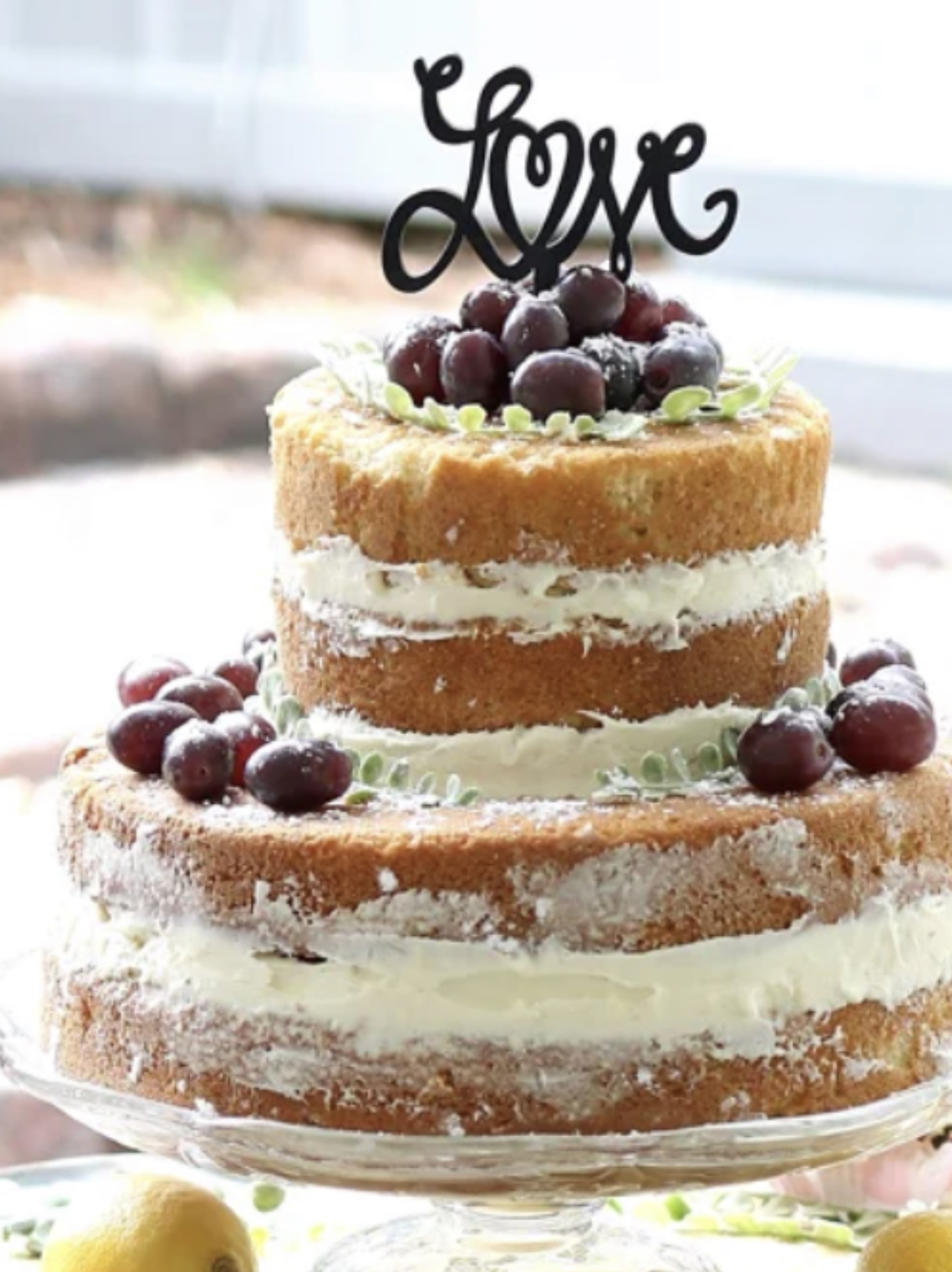 Picture depicts two tier naked wedding cake decorated with cream cheese frosting and fresh fruit