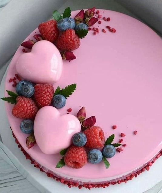 Picture of pretty pink valentines cake, moist flavoured sponge filled with choice of buttercream fruit ganache cream cheese frosting and topped with fondant, fresh fruit and chocolate hearts.